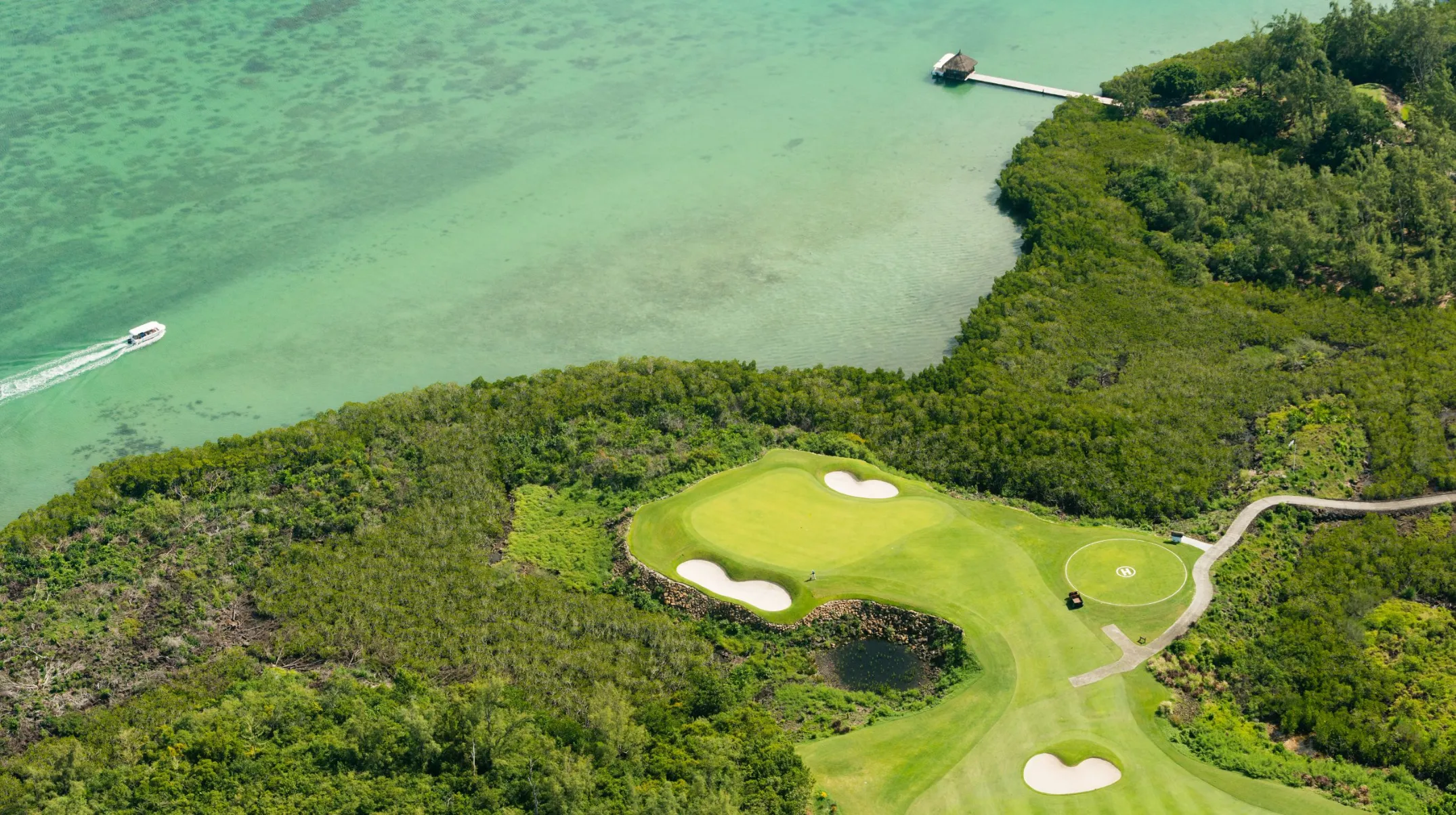 Île Maurice — Terrain de golf entouré d'une nature luxuriante et d'eaux turquoise, offrant un cadre idyllique.