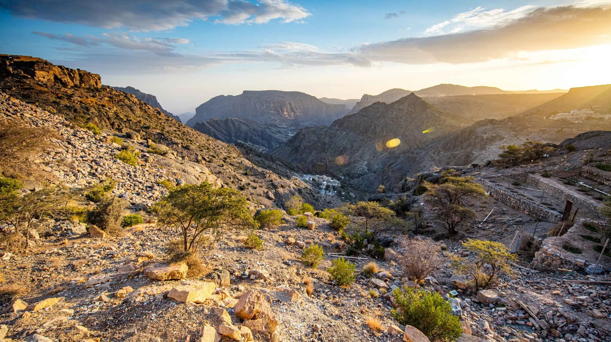 Paysage montagneux du Jabal Akhdar au coucher du soleil, dans les montagnes du Hajar à Oman. destination nature et authenticité pour voyageurs suisses en quête d’évasion.