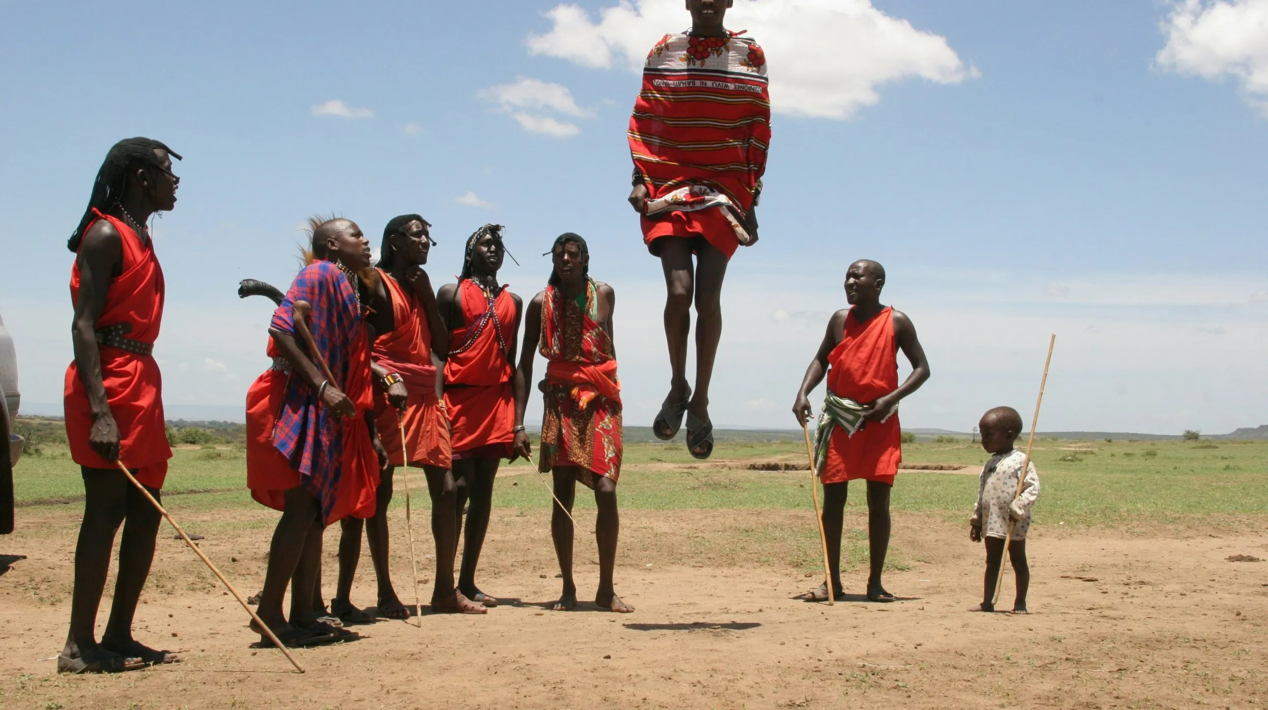 Célébration traditionnelle des Maasaï, Afrique du Sud — danse rythmée sous un ciel ensoleillé.
