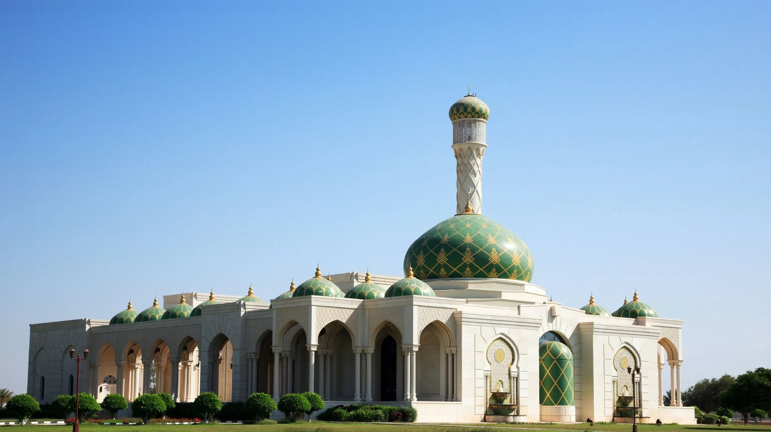 Mosquée Sultan Qaboos à Mascate, Oman, célèbre pour son architecture raffinée et son dôme vert orné de motifs dorés.