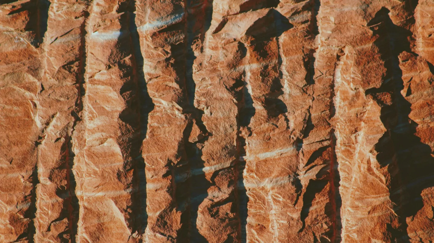 Vue aérienne des formations rocheuses striées des gorges d’Olduvai en Tanzanie, site archéologique emblématique et témoignage unique des origines de l’humanité dans un décor volcanique.