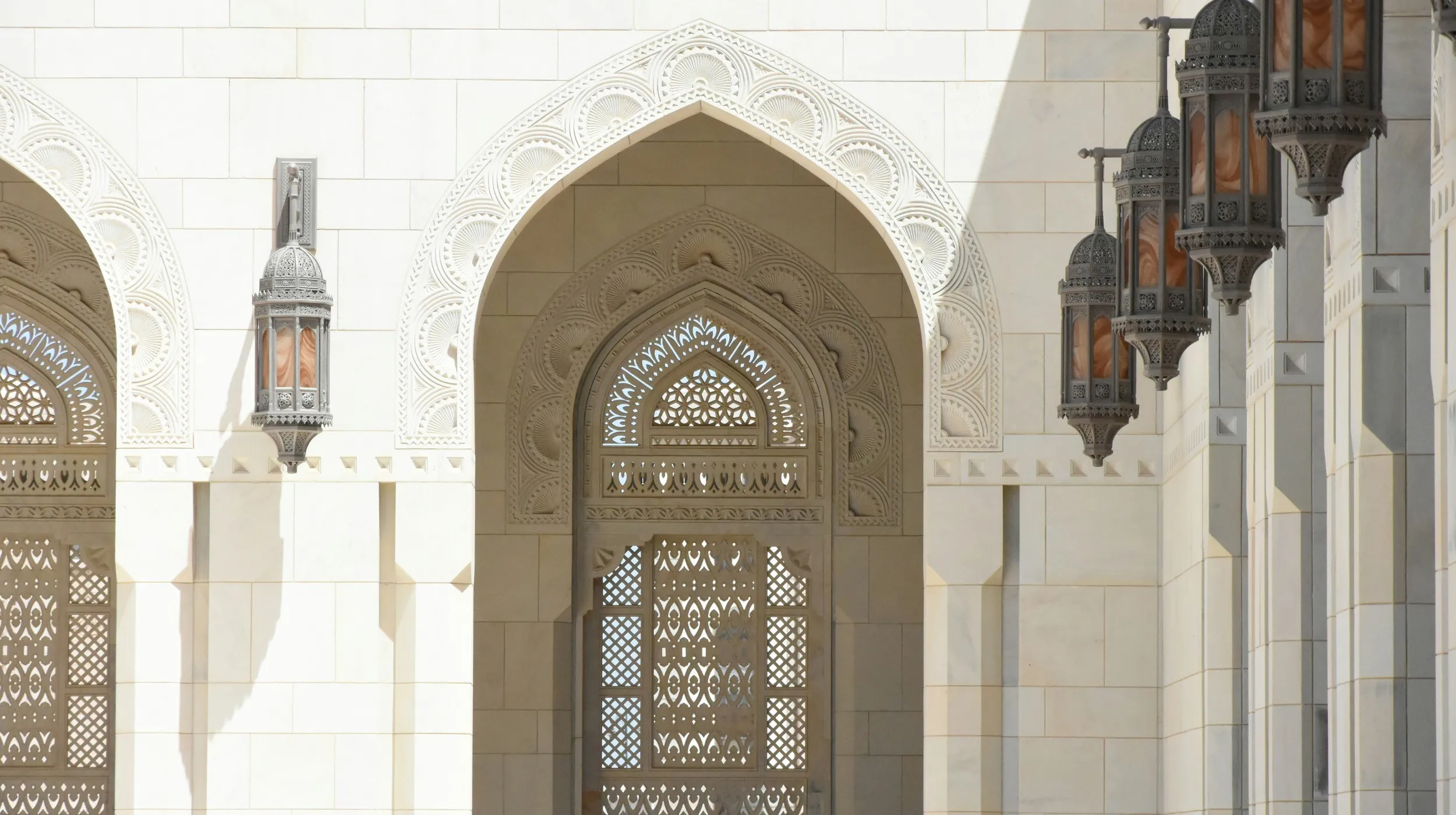 Architecture majestueuse à Oman et lumineuse, ornée de lanternes, évoquant un charme intemporel.