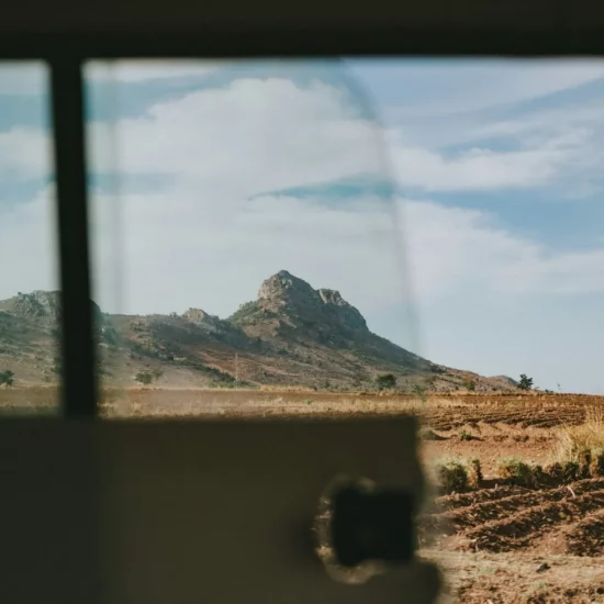 Un panorama époustouflant de collines se dévoile à travers la fenêtre, invitant à l'aventure et à l'exploration.