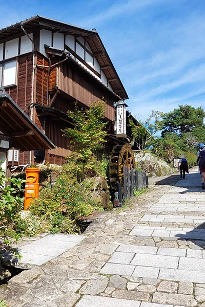 Rue pittoresque avec un moulin à eau, Japon — ambiance tranquille et authentique.