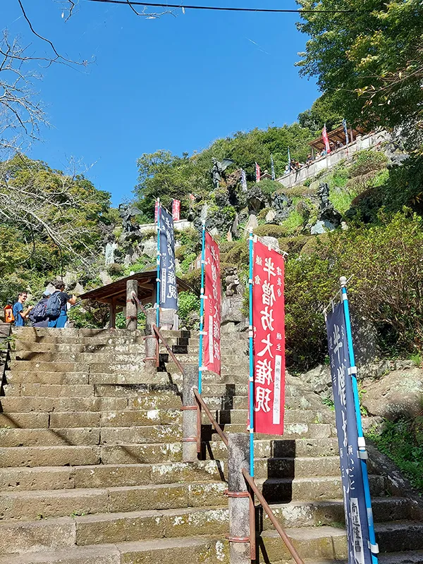 Escaliers en pierre menant à un site historique, Japon — ambiance paisible et envoûtante sous un ciel bleu.