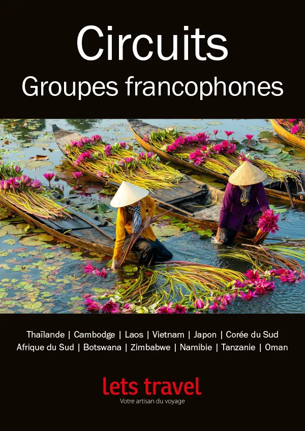 Scène paisible de femmes en barque récoltant des fleurs sur un plan d'eau, entourées de végétation luxuriante.