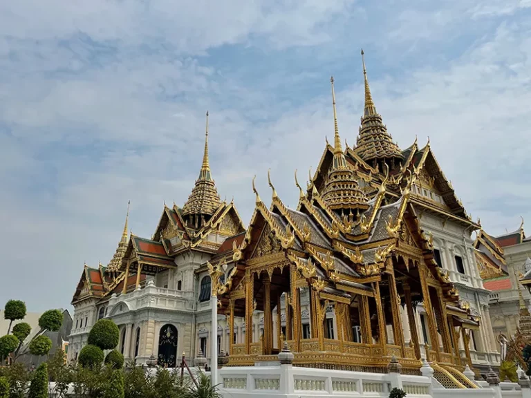 Palais royal, Thaïlande — architecture majestueuse ornée de dorures sous un ciel lumineux.