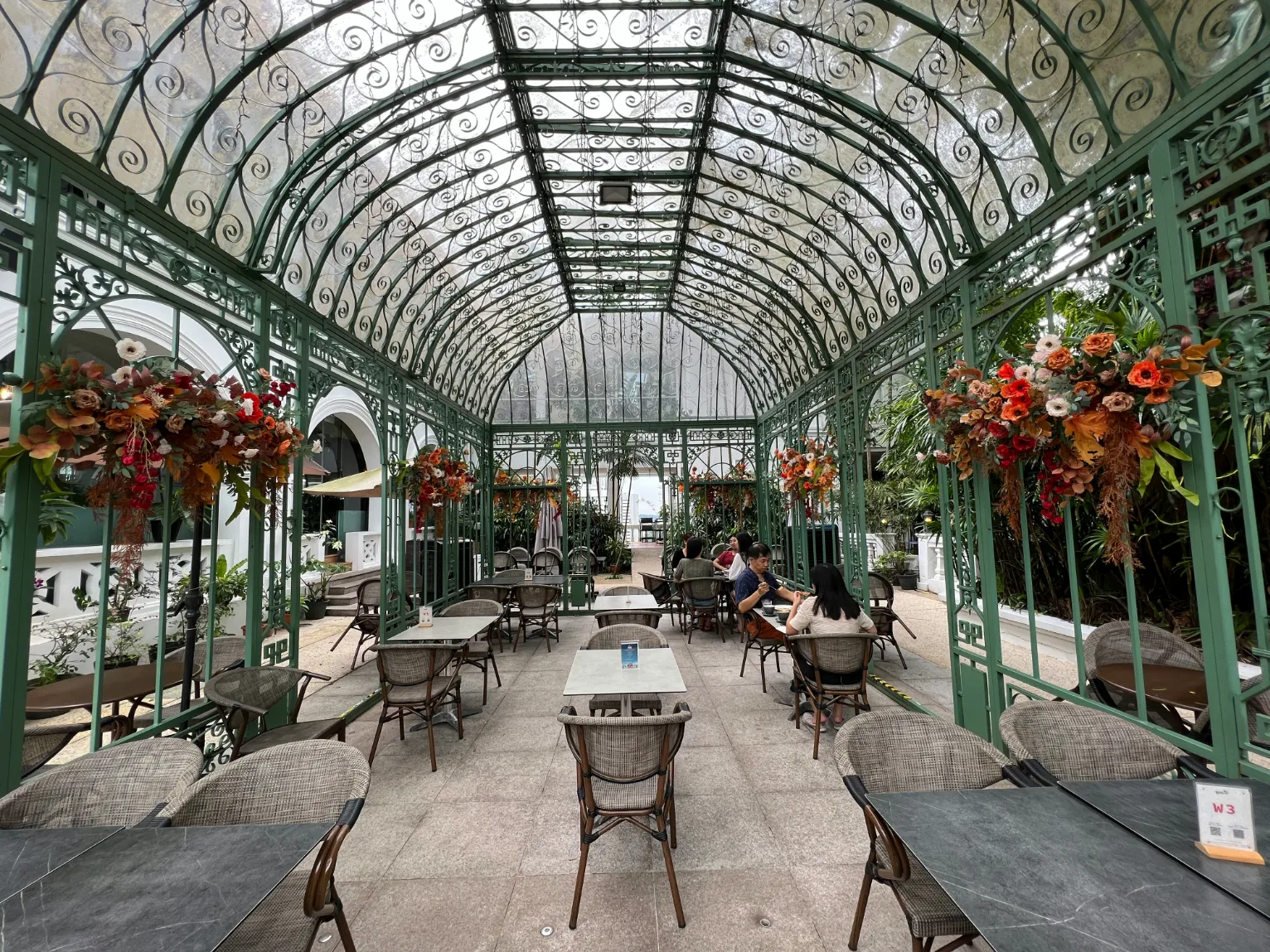Un cadre enchanteur avec des tables élégantes, idéal pour un moment paisible au cœur d'une végétation luxuriante.