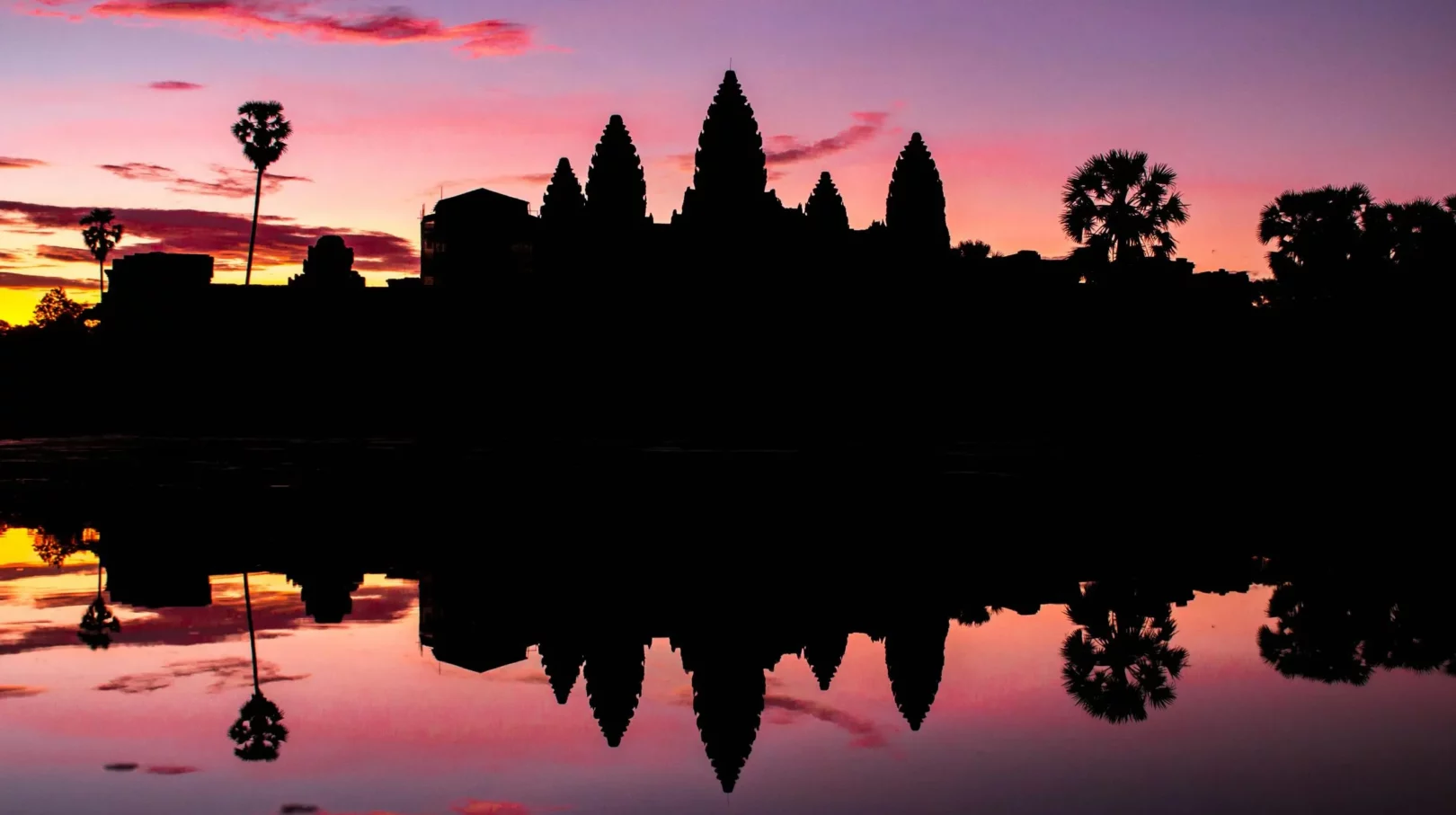 Angkor, Cambodge — silhouette majestueuse des temples au coucher de soleil, reflet enchanteur sur l'eau.