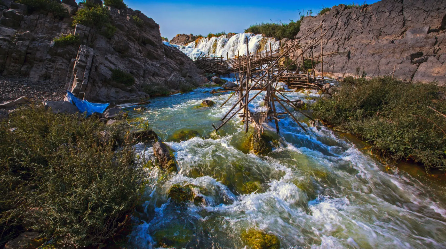 Un paysage naturel au Laos -  époustouflant avec des cascades et des eaux vives bordées de rochers et de verdure.