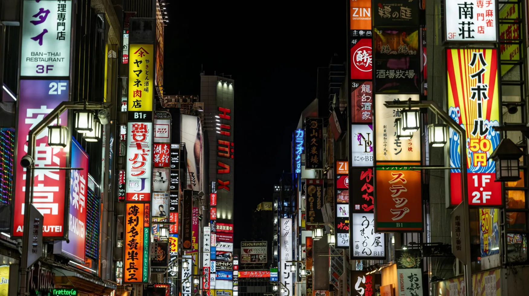 Tokyo, Japon — rue animée illuminée par des néons colorés, créant une ambiance vibrante et nocturne.