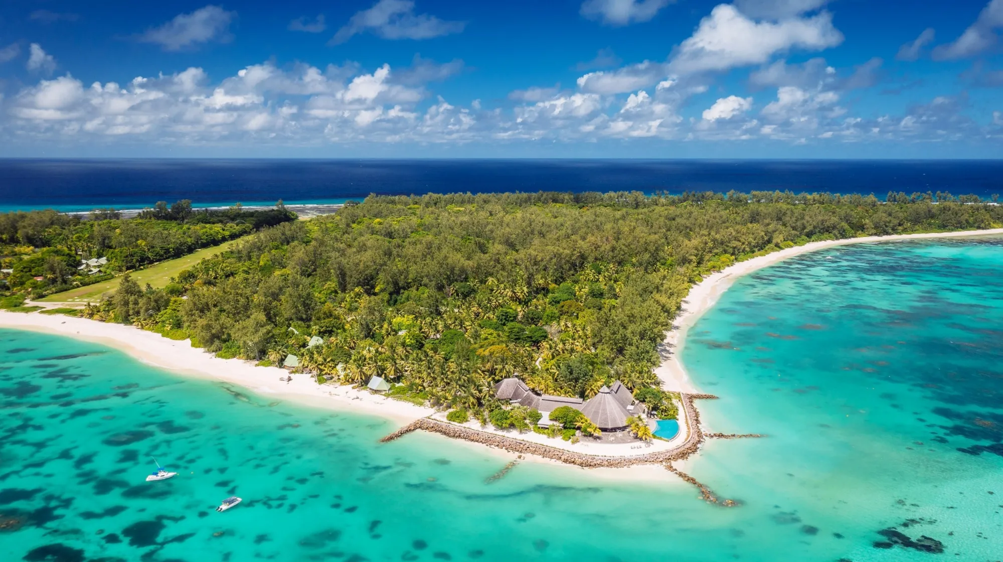 Denis Private Island — Plage paradisiaque bordée de palmiers et eaux turquoise scintillantes.