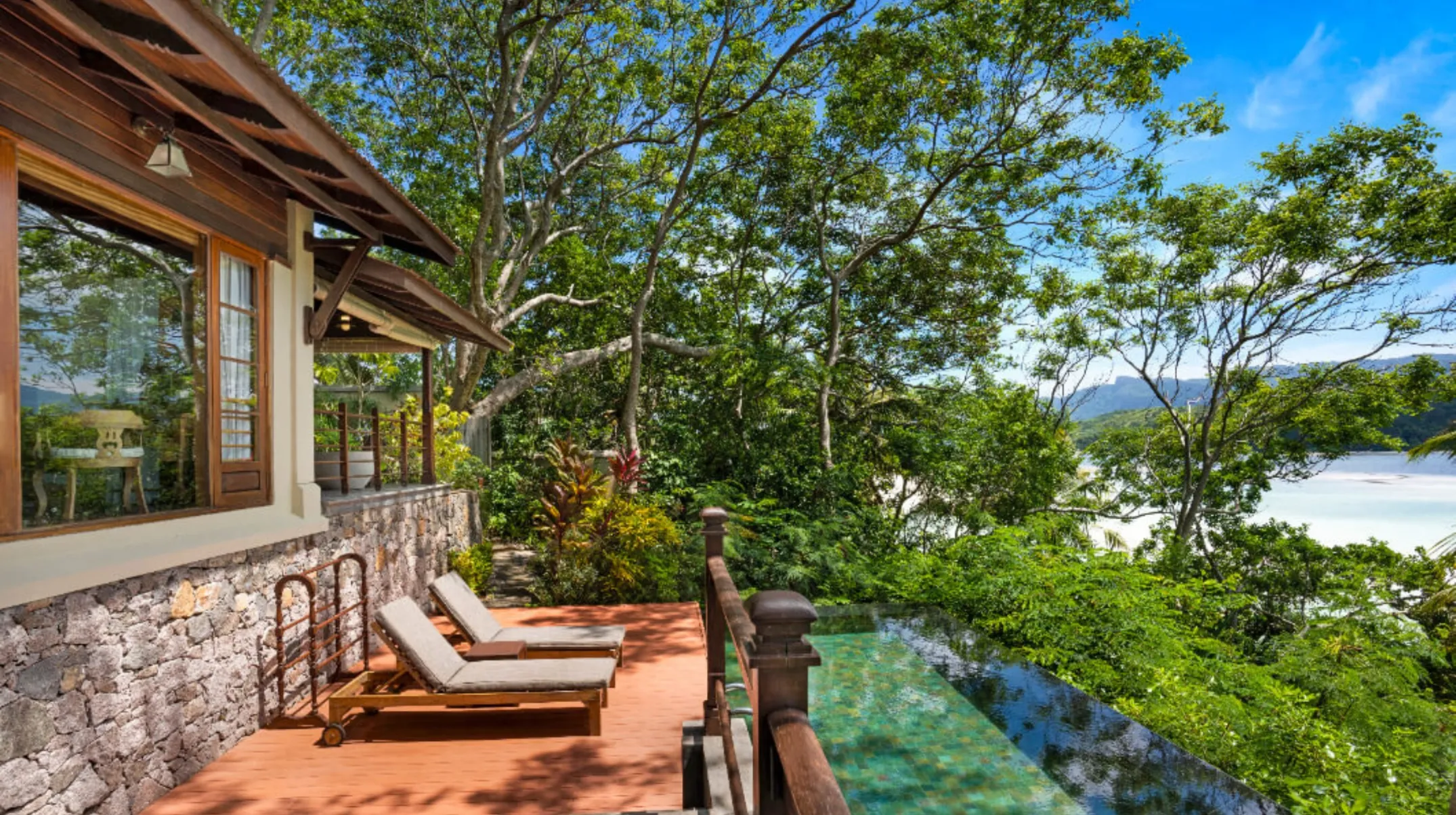 Vue idyllique d'une villa entourée de végétation luxuriante, avec une piscine à débordement, paisible et apaisante aux Seychelles