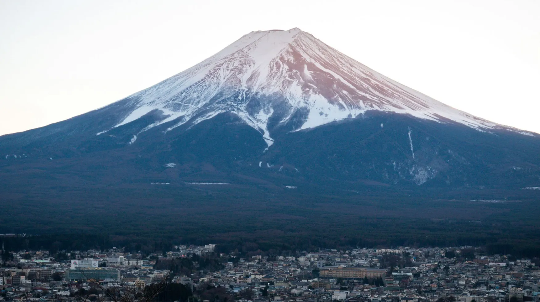 Mont Fuji, Japon — majestueuse montagne recouverte de neige surplombant une ville pittoresque.