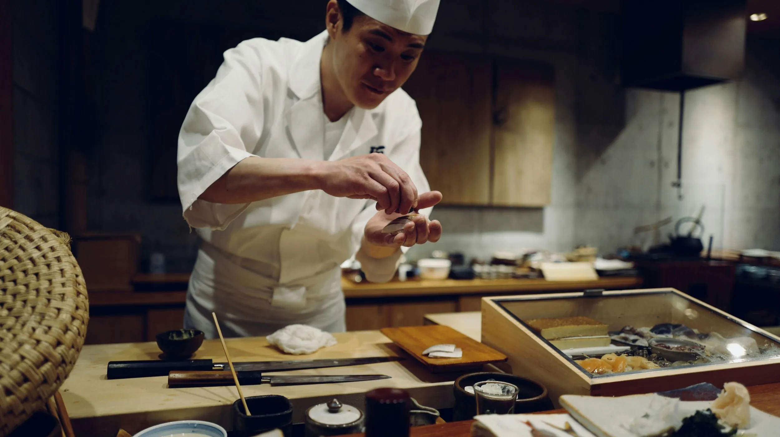 Chef cuisinier japonais préparant des plats raffinés dans un restaurant traditionnel, ambiance chaleureuse et conviviale.