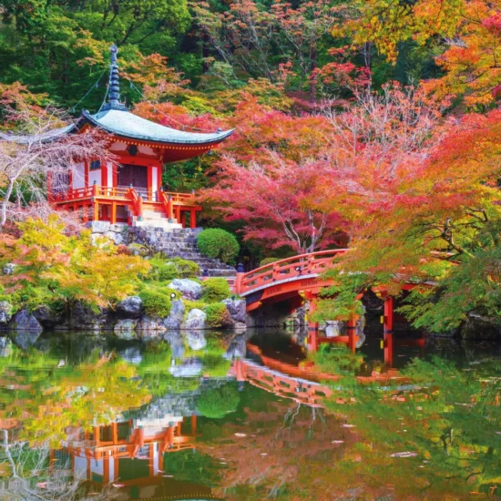 Japon — Un temple majestueux se reflète paisiblement dans un étang, entouré d'arbres aux couleurs éclatantes.