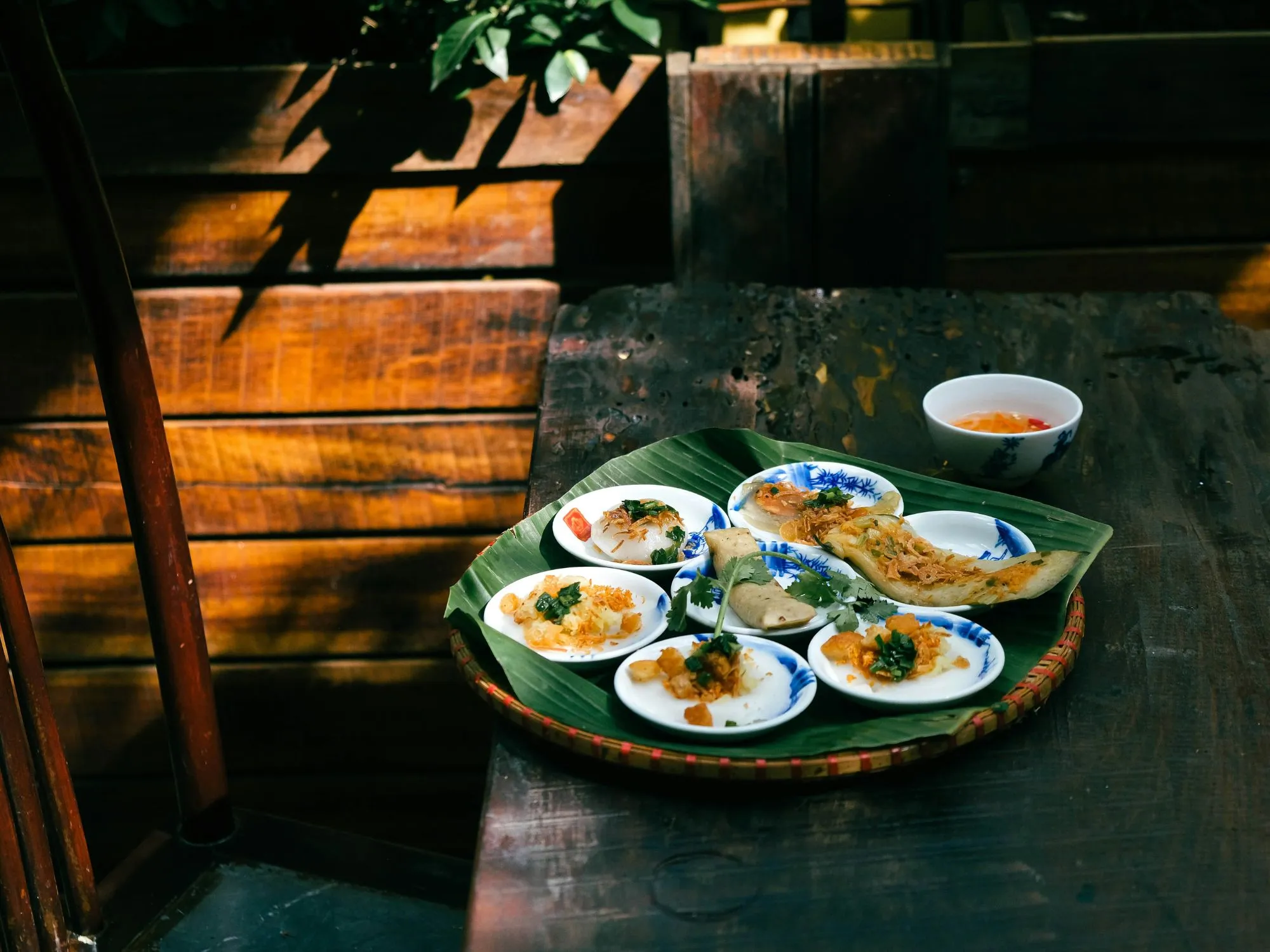 Plats colorés servis sur une feuille de bananier, ambiance chaleureuse et accueillante.