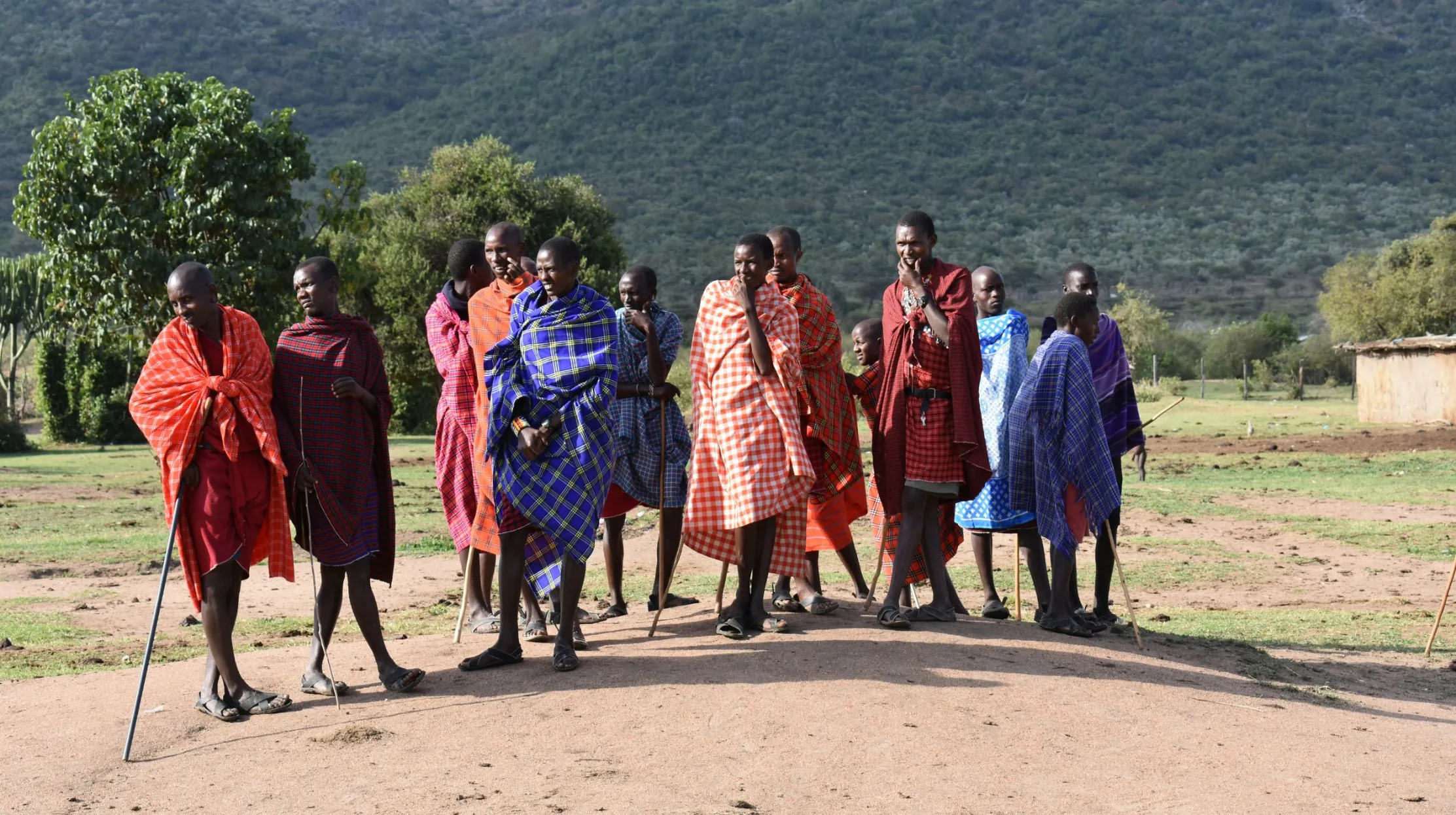 Groupe de personnes en vêtements traditionnels, Kenya — moment culturel captivant dans un paysage rural.