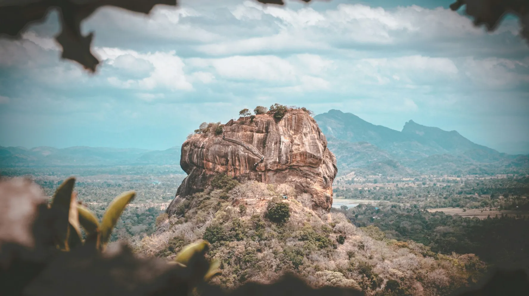 Montagne majestueuse entourée de paysages verdoyants, offrant une vue spectaculaire sur la nature environnante.