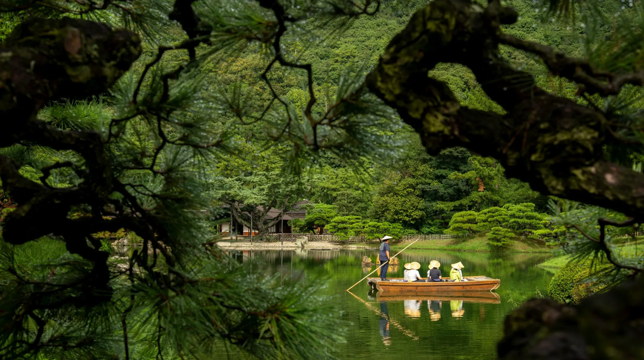 Un moment paisible au Japon — une promenade en barque sur un lac enchanteur, entouré de verdure luxuriante.