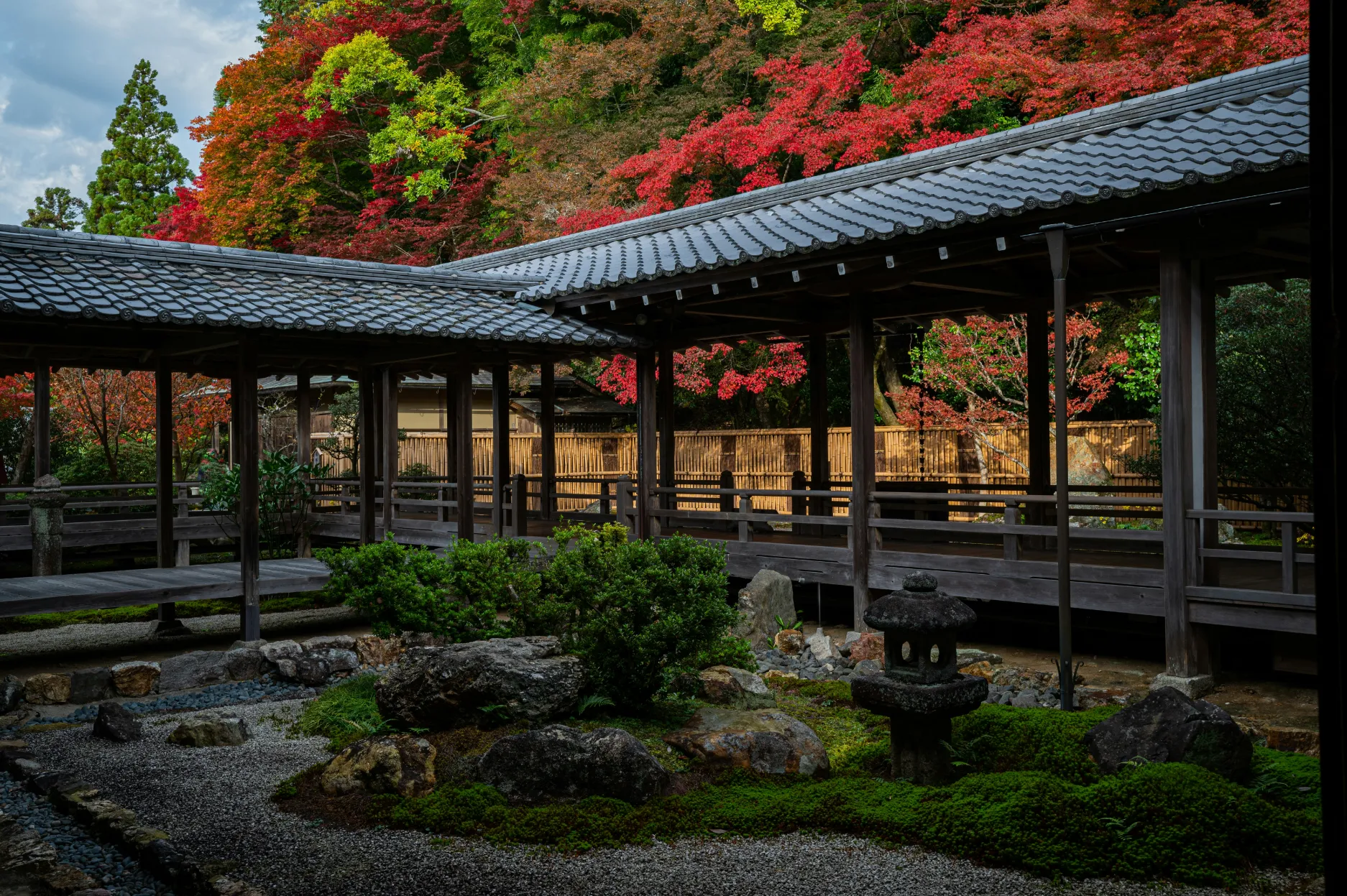 Jardin paisible avec des feuilles d'érable colorées et une architecture traditionnelle japonaise à Kyoto.