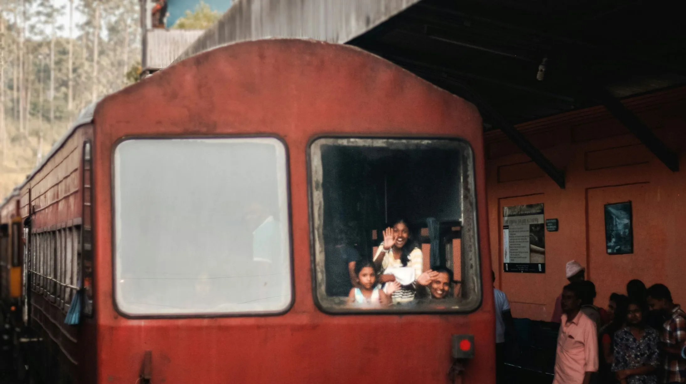 Train coloré dans une gare animée, ambiance conviviale et chaleureuse, évoquant l'authenticité d'un voyage.