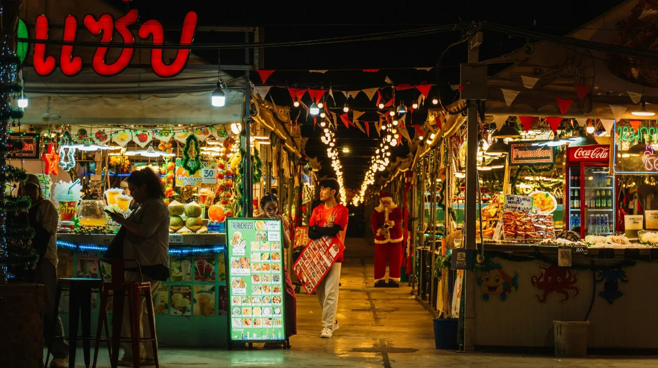 Marché nocturne animé, Thaïlande — ambiance colorée et conviviale sous les lumières scintillantes.