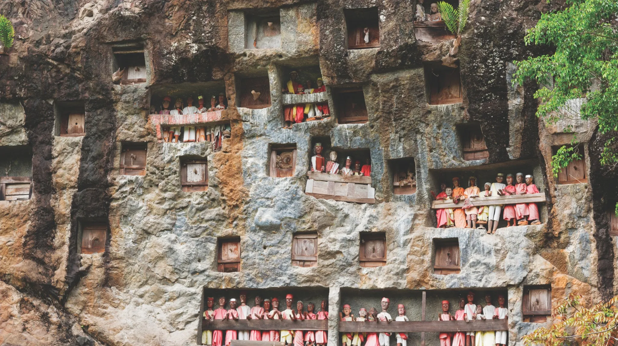 Scène historique avec des statues sculptées dans une falaise, évoquant des traditions ancestrales et mystérieuses.