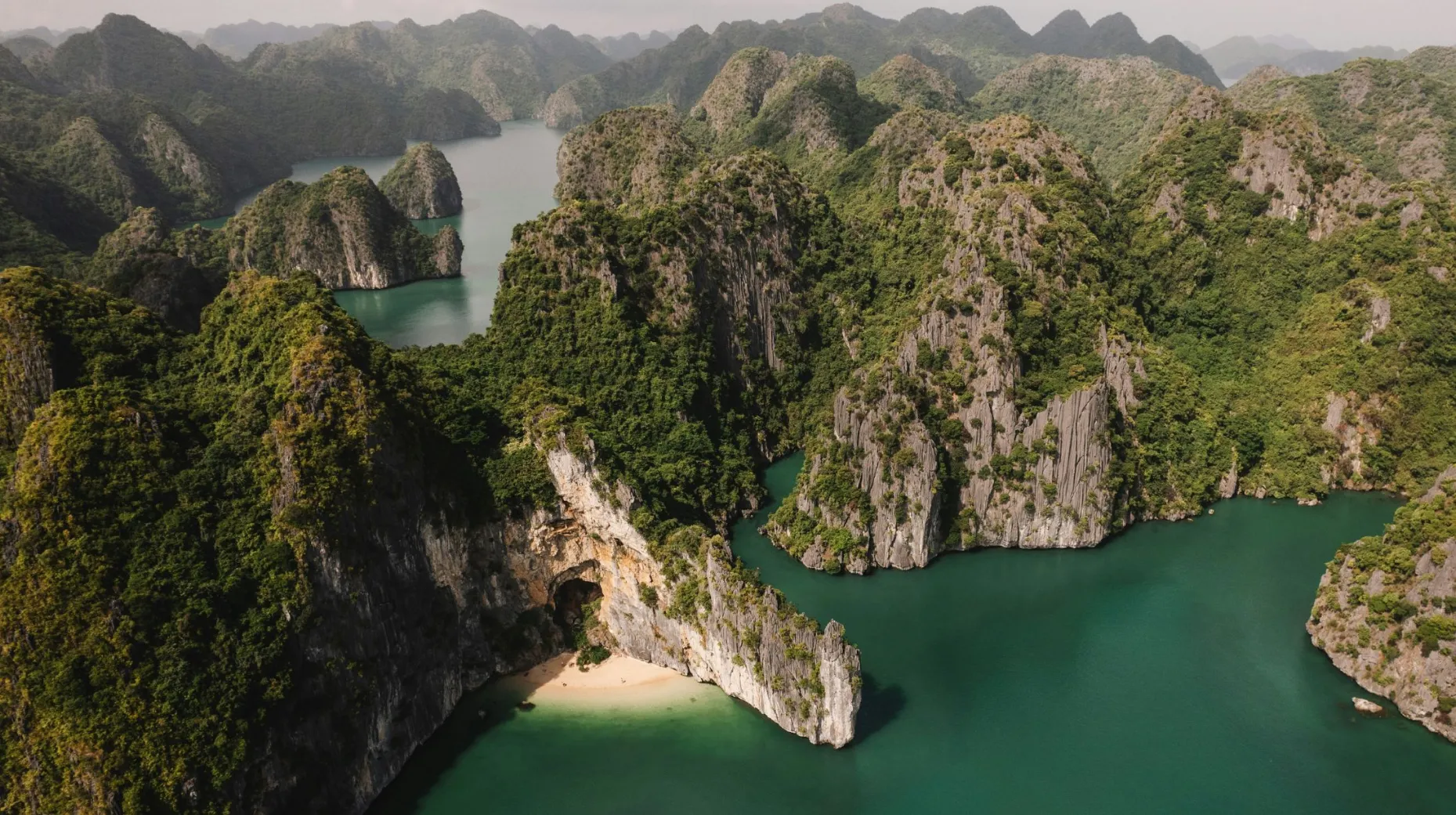 Vietnam — paysage spectaculaire de montagnes verdoyantes entourant des eaux turquoise.