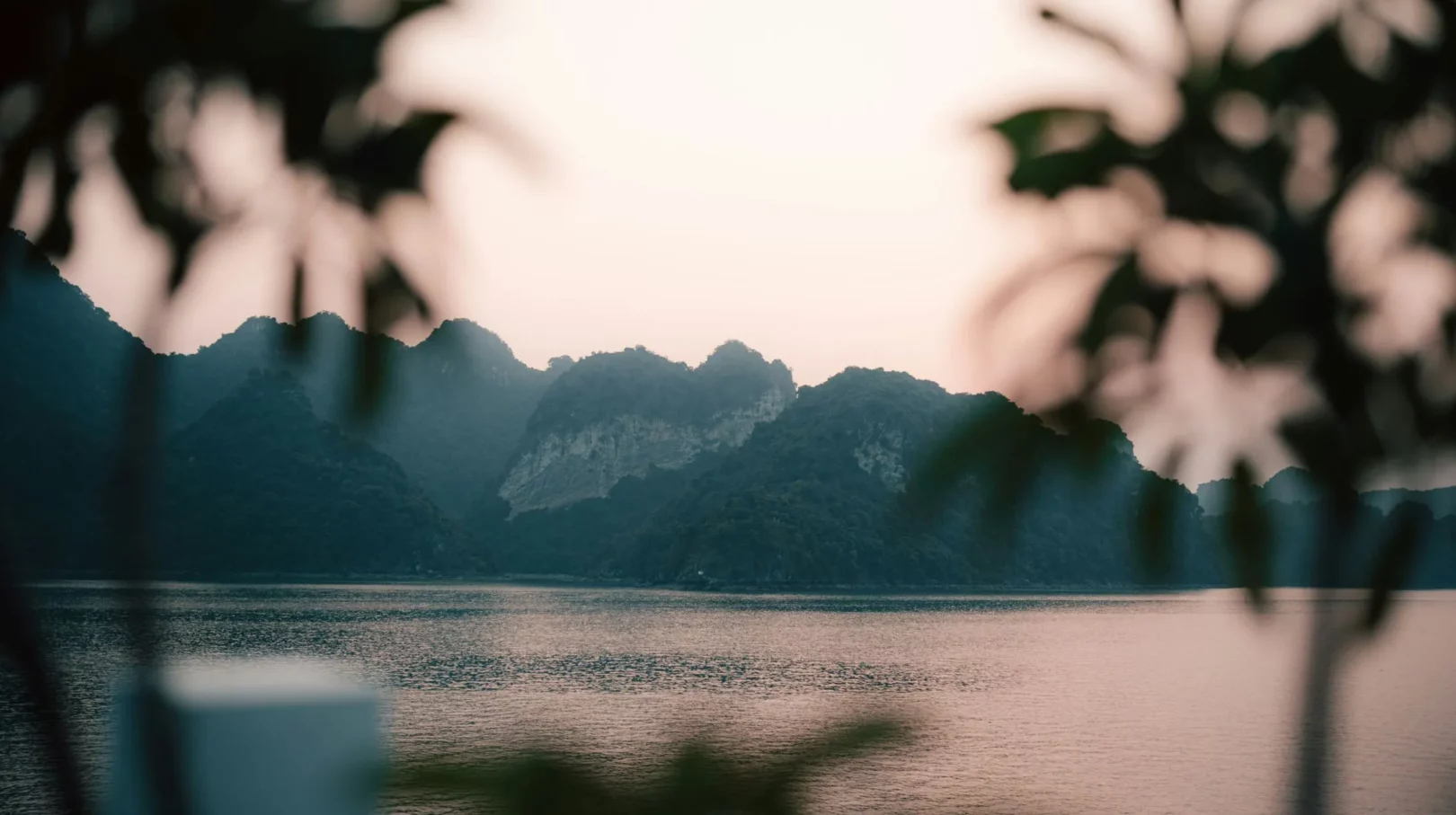 Paysages majestueux au crépuscule, entre montagnes et eaux tranquilles, évoquant une atmosphère apaisante.