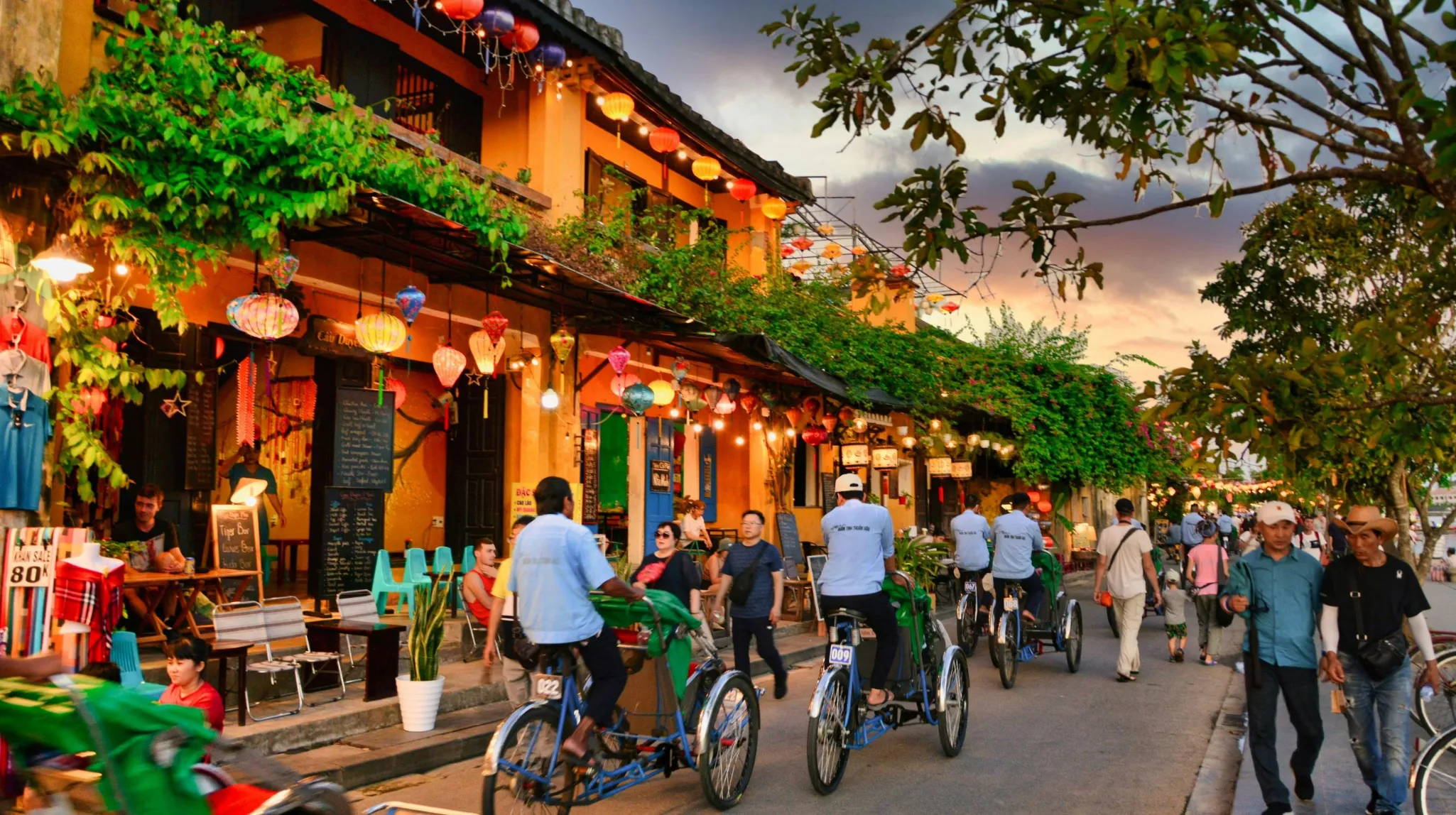 Hoi An, Vietnam — rue animée bordée de lanternes colorées et de verdure luxuriante.