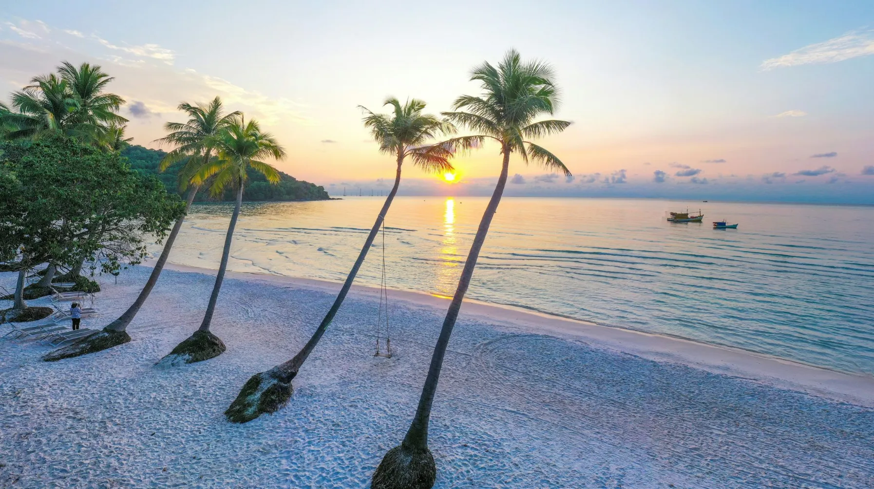 Vietnam- Plage de Phu Quoc, tranquille avec palmiers, reflet du soleil sur l'eau, ambiance idyllique et apaisante.