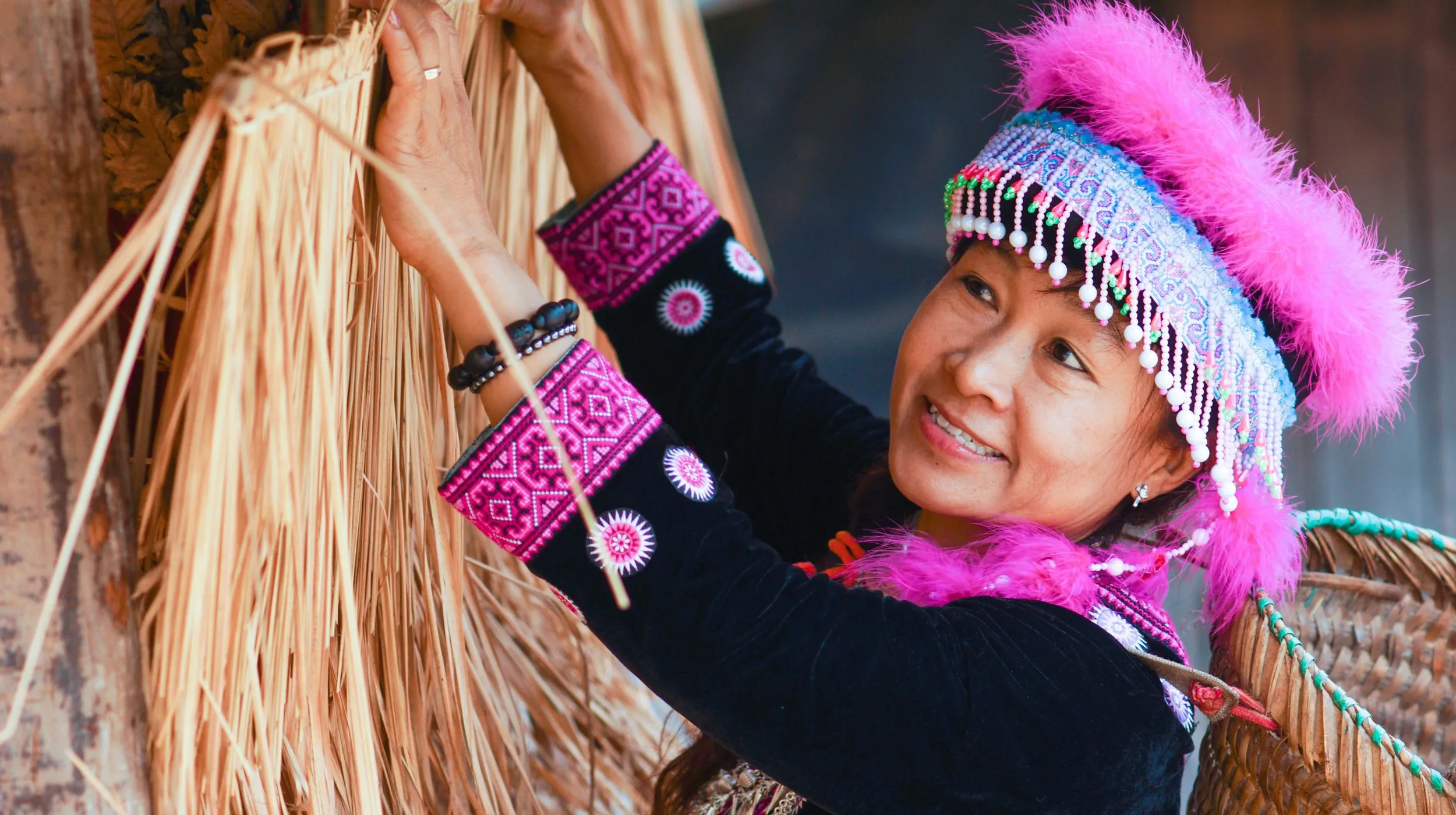 Femme en tenue traditionnelle, travaillant avec des matériaux naturels dans un cadre enchanteur.
