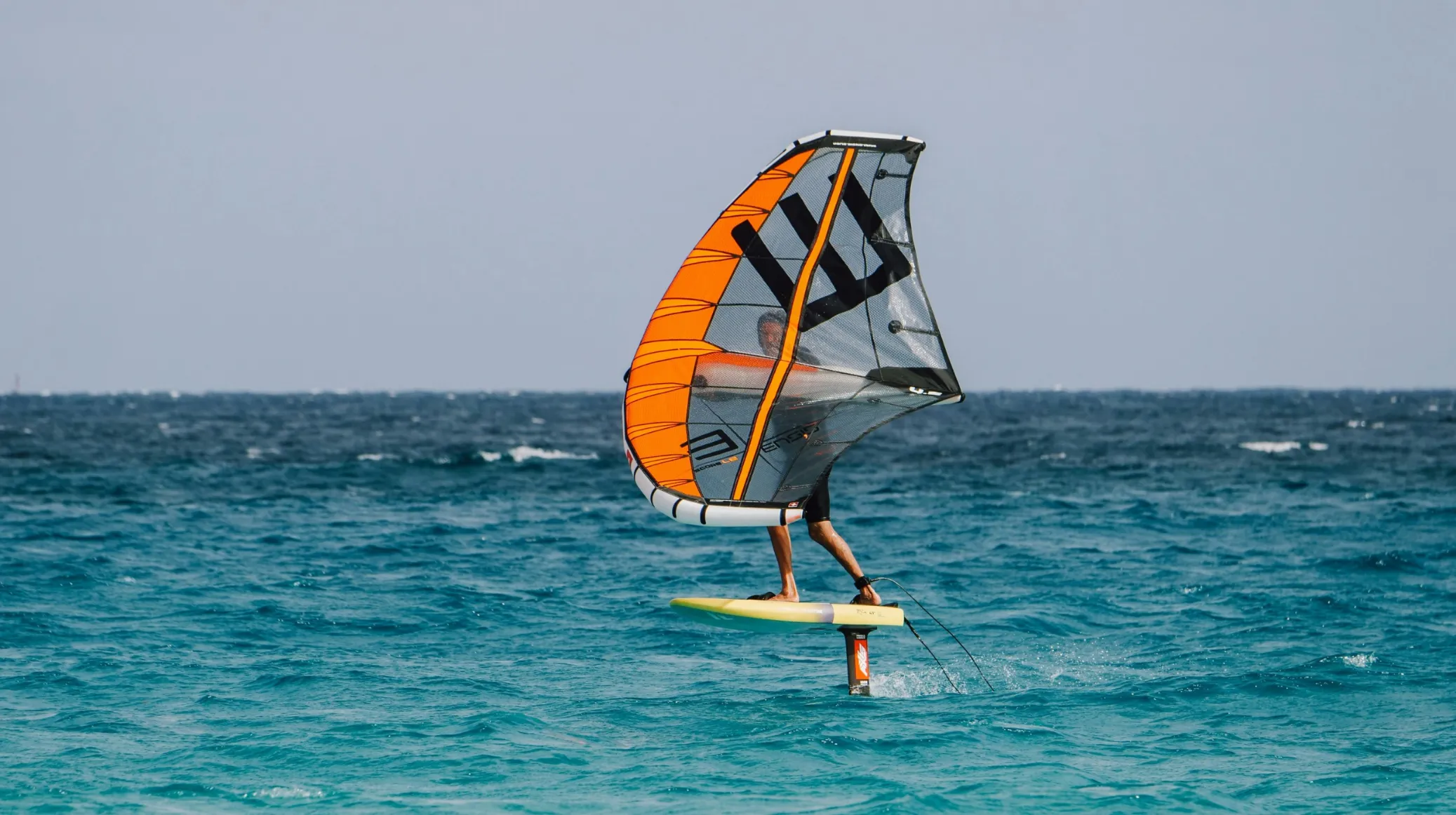 Activité de windsurf sur une mer turquoise, ambiance tropicale et envoûtante.