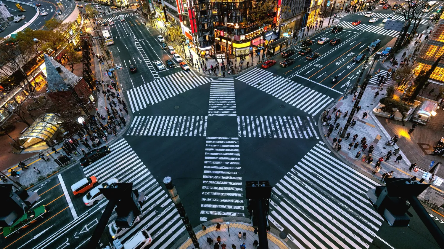 Tokyo, Japon — scène animée d'un carrefour avec des piétons et des véhicules sous les lumières vibrantes de la ville.