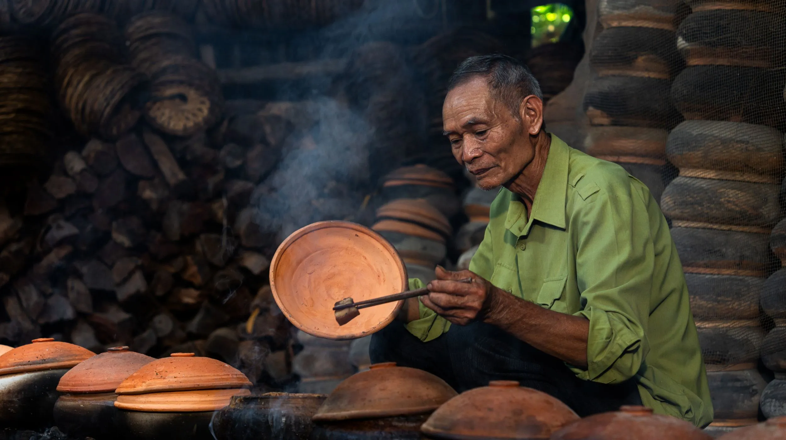 Artisan potier au travail, créant des œuvres en terre cuite dans un environnement traditionnel et chaleureux.