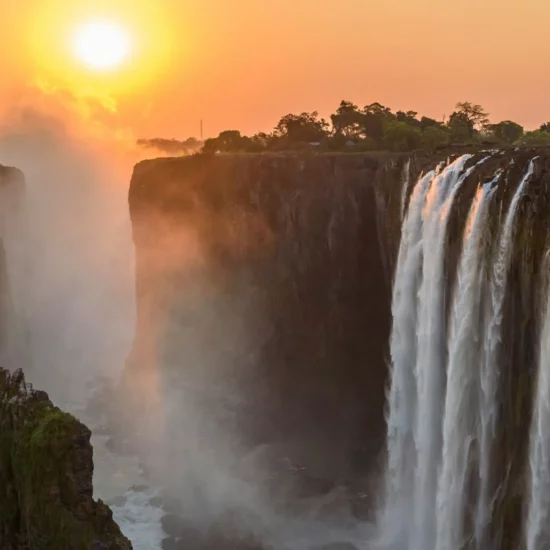 Chutes Victoria, Zimbabwe — un spectacle époustouflant où l'eau danse sous les rayons dorés du soleil couchant.
