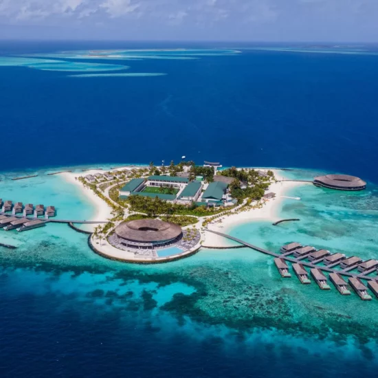 Île paradisiaque aux Maldives — eaux turquoise et villas sur pilotis entourées de plages de sable fin.